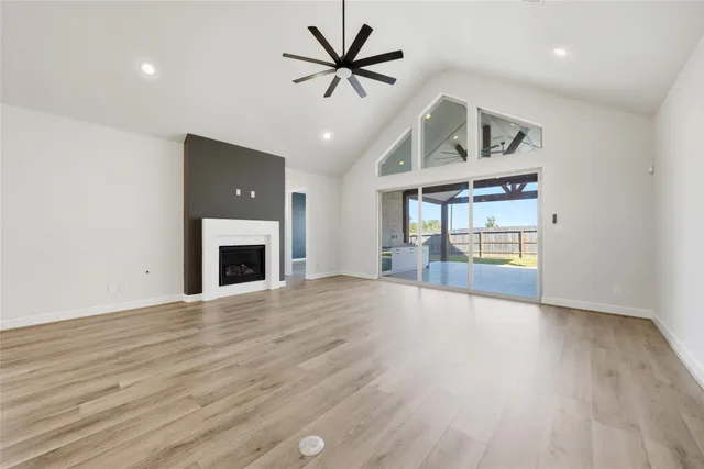 an empty room with fan and a fireplace
