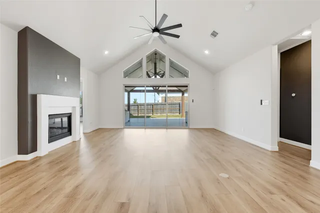 a view of an empty room with a fireplace and a window