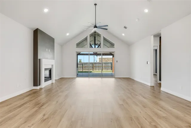 a view of an empty room and window and wooden floor