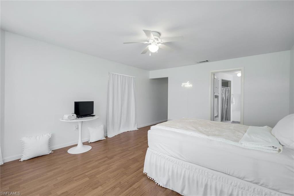 59 Hilo Court, Unit 59 Naples, FL 34112 - Photo 14 of 25 a bedroom with a bed and a flat tv screen on dresser