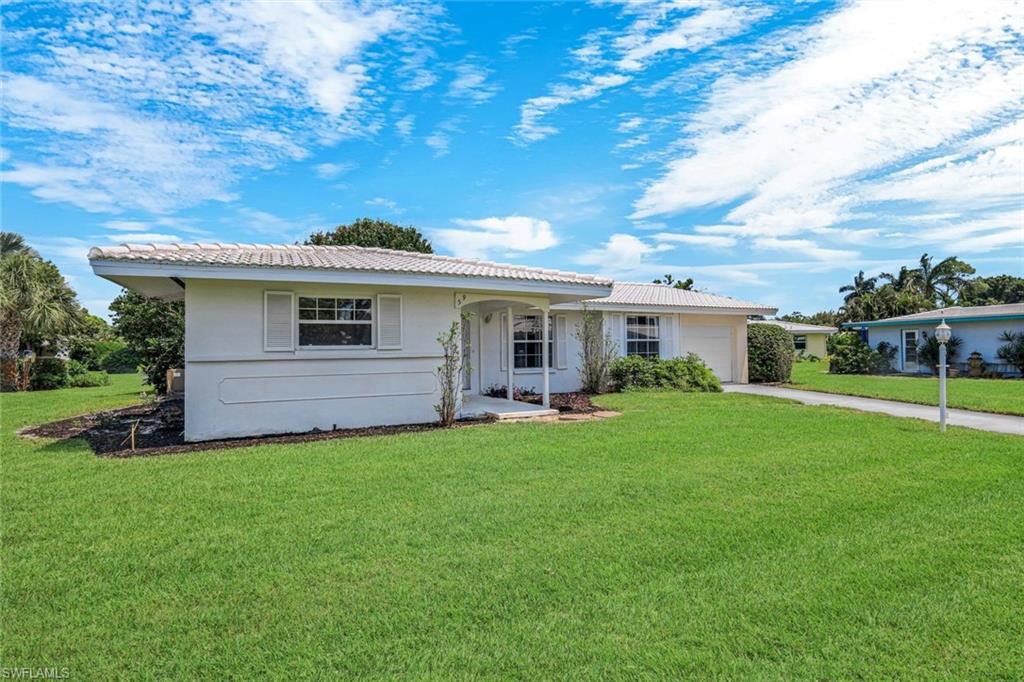 59 Hilo Court, Unit 59 Naples, FL 34112 - Photo 2 of 25 a front view of house with a garden