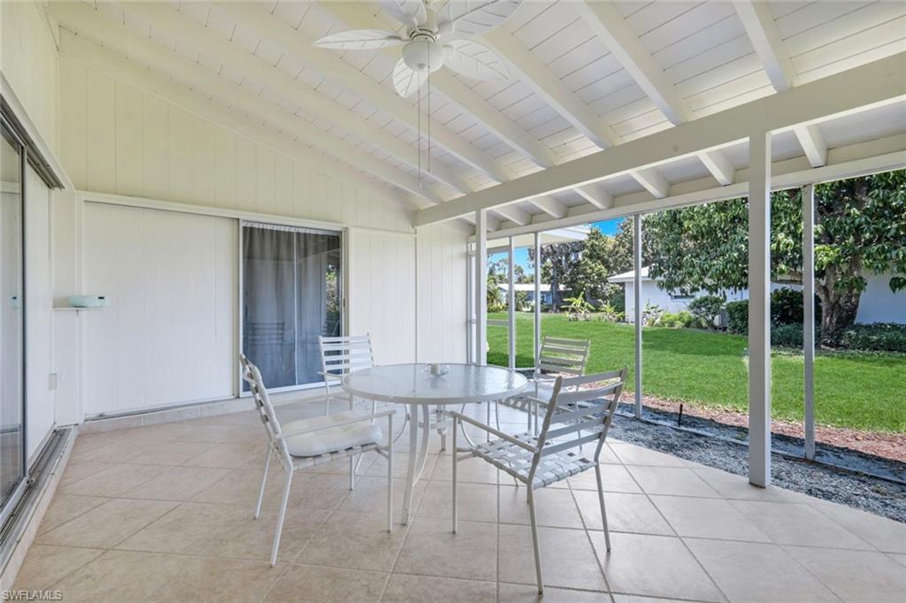59 Hilo Court, Unit 59 Naples, FL 34112 - Photo 21 of 25 a patio with yard glass top table and chairs
