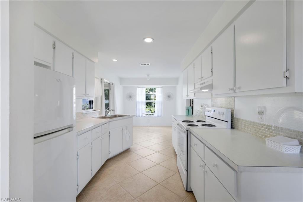 59 Hilo Court, Unit 59 Naples, FL 34112 - Photo 9 of 25 a kitchen with stainless steel appliances a sink stove and cabinets