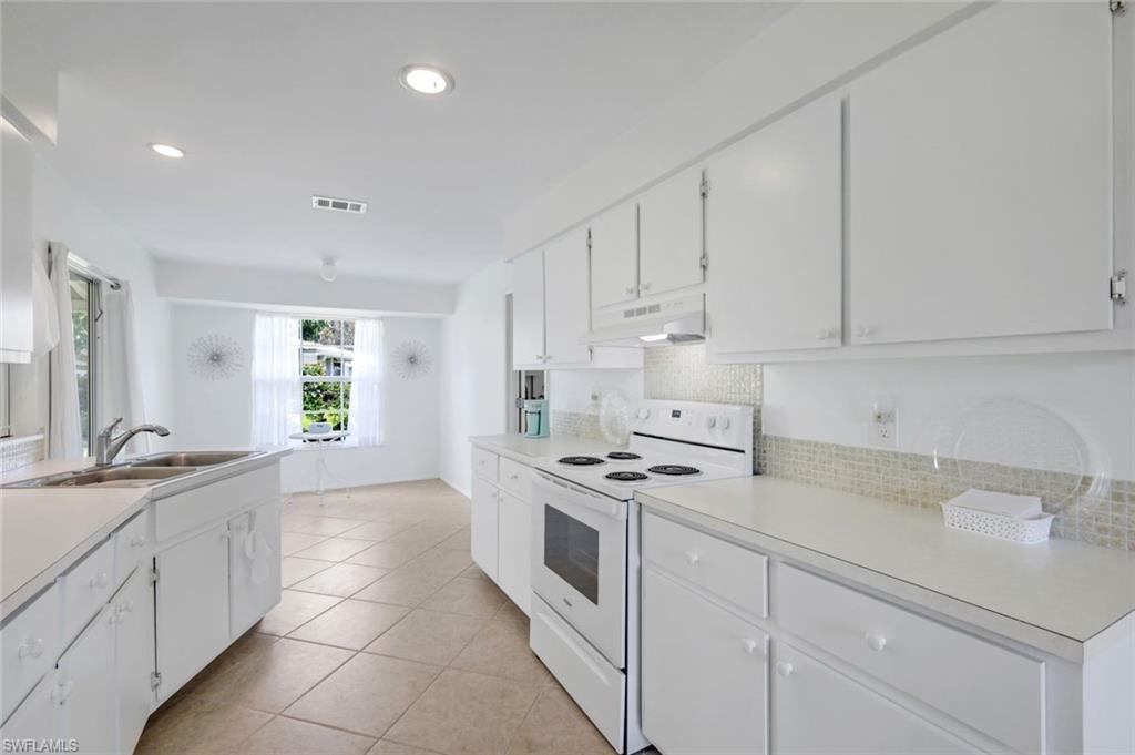 59 Hilo Court, Unit 59 Naples, FL 34112 - Photo 10 of 25 a kitchen with granite countertop white cabinets and white appliances