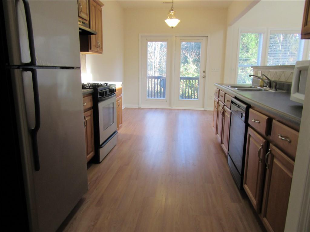 3357 Wyesham Circle Duluth, GA 30096 - Photo 12 of 26 a kitchen with stainless steel appliances wooden floors and wooden cabinets