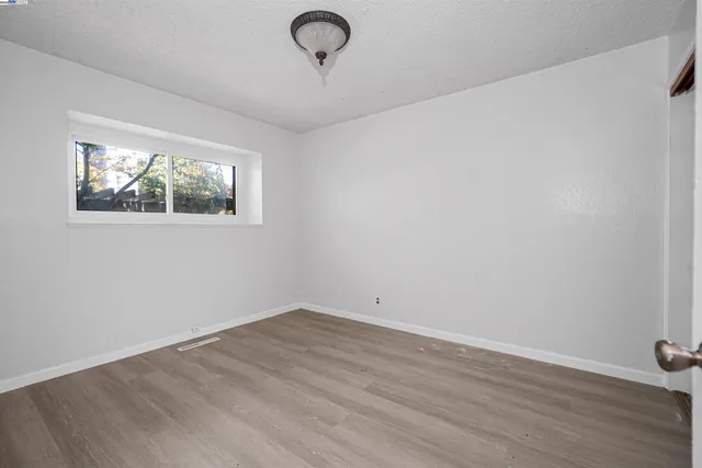 an empty room with windows and ceiling fan