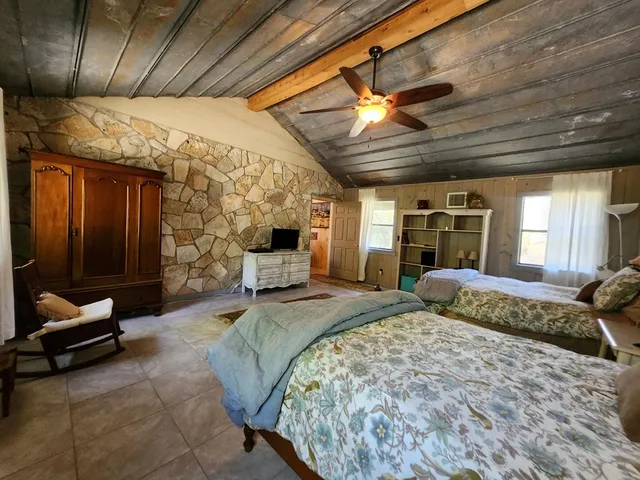 a spacious bedroom with a bed a chandelier and closet