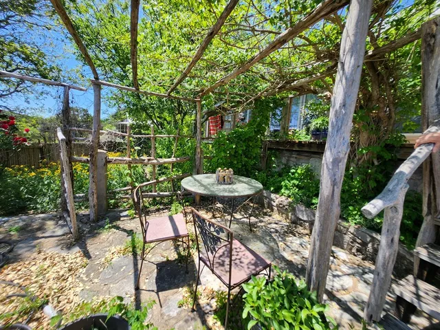a view of a chairs and table in backyard