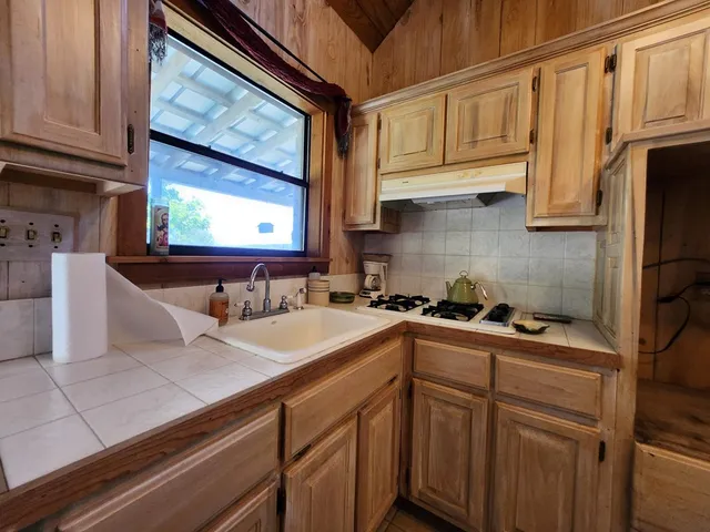a kitchen with stainless steel appliances granite countertop a sink and a stove