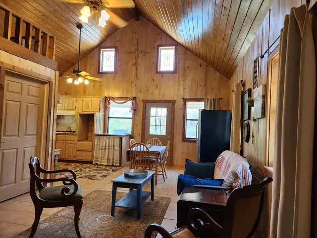 a living room with furniture a flat screen tv and large window