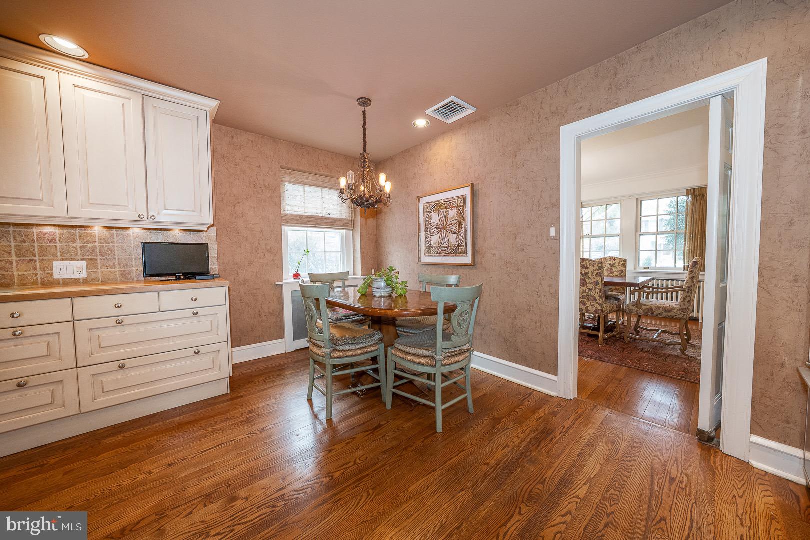 517 Howe Road Merion Station, PA 19066 - Photo 18 of 71 a dining room with wooden floor a chandelier a glass table and chairs