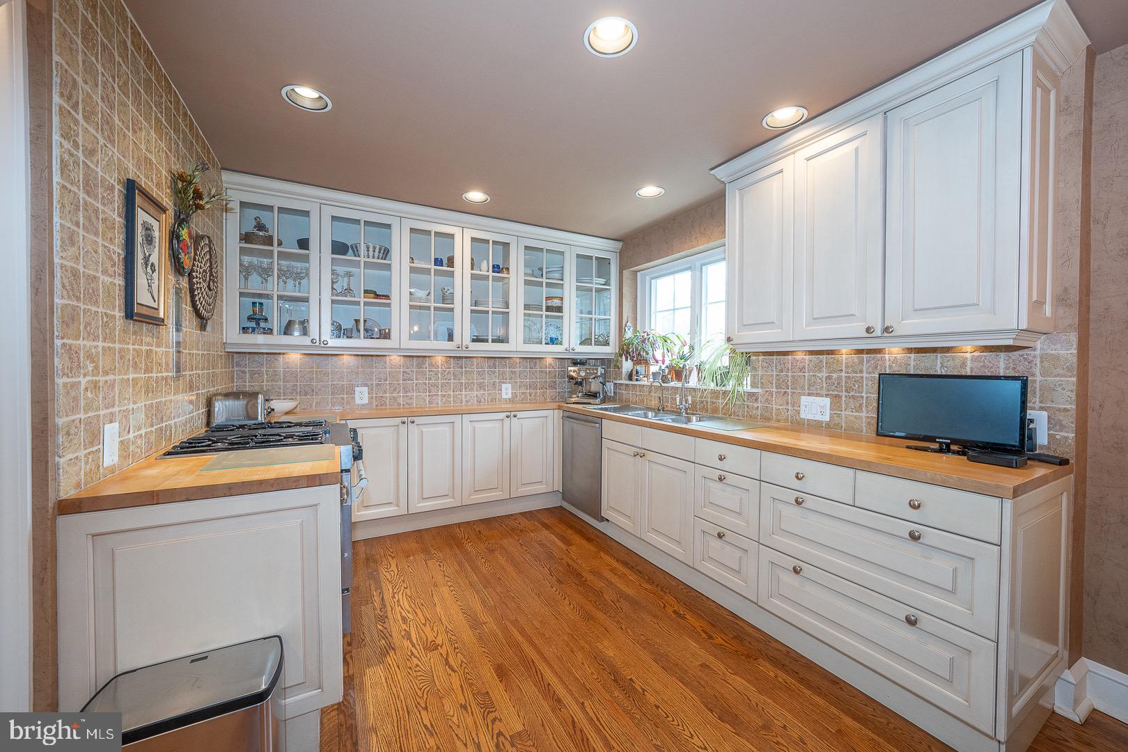517 Howe Road Merion Station, PA 19066 - Photo 20 of 71 a kitchen with granite countertop wooden cabinets a sink and dishwasher with wooden floor