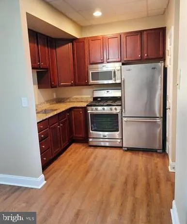 a kitchen with stainless steel appliances granite countertop a refrigerator sink and cabinets