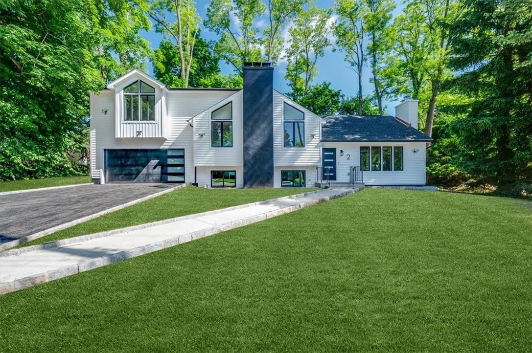 View of front of home with a garage and a front yard