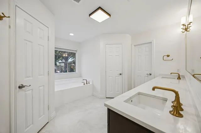 a bathroom with a tub sink and mirror