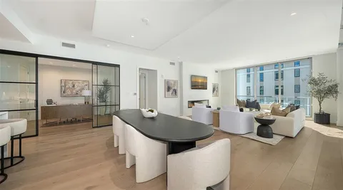 a living room with couches a coffee table and chairs with wooden floor
