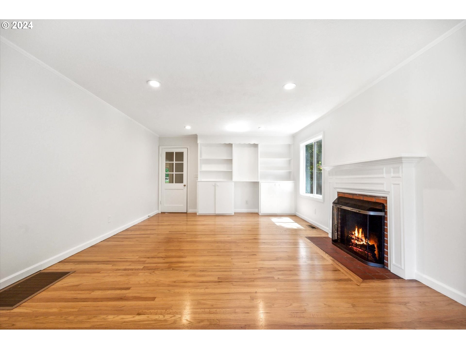 10097 Southwest Walker Road Portland, OR 97225 - Photo 13 of 44 a view of an empty room with wooden floor fireplace and a window