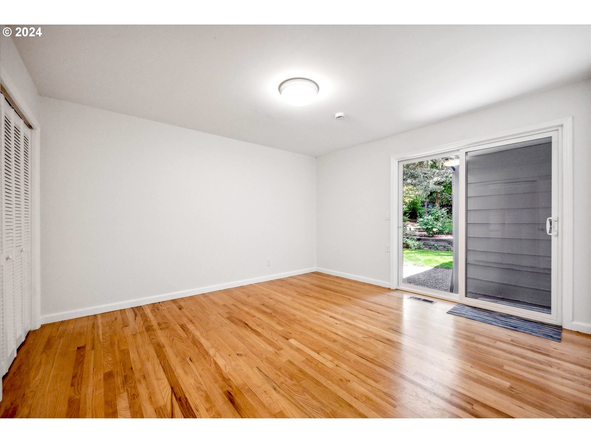 10097 Southwest Walker Road Portland, OR 97225 - Photo 14 of 44 a view of an empty room with wooden floor and a window