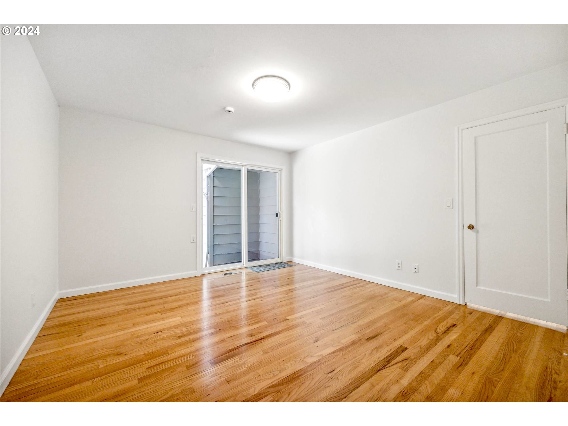 10097 Southwest Walker Road Portland, OR 97225 - Photo 17 of 44 a view of an empty room with wooden floor and a window