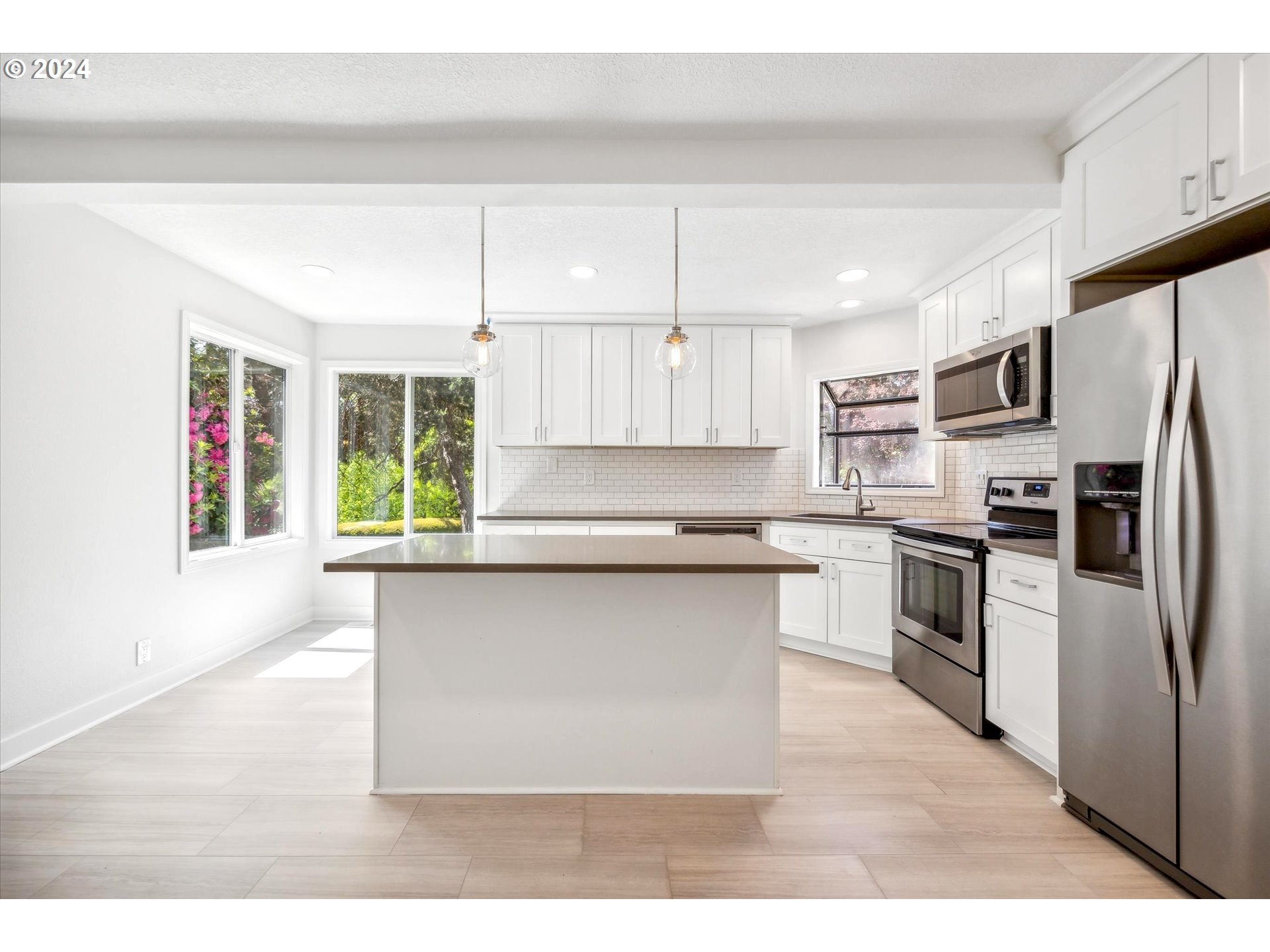 10097 Southwest Walker Road Portland, OR 97225 - Photo 8 of 44 a kitchen with kitchen island a counter top space a sink cabinets and stainless steel appliances