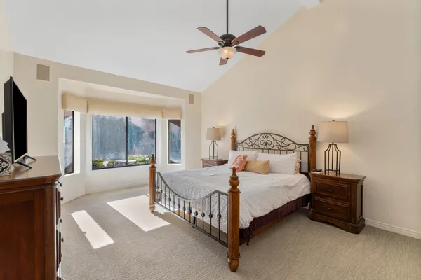 a bedroom with a bed chandelier and a window
