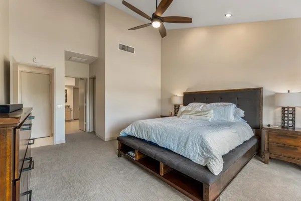 a spacious bedroom with a bed and a ceiling fan
