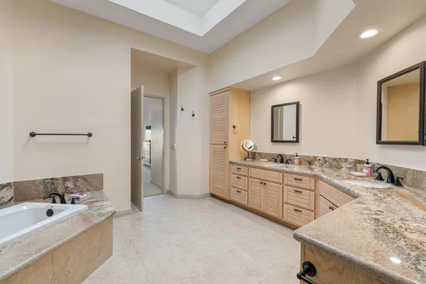 a bathroom with a granite countertop sink mirror and bathtub