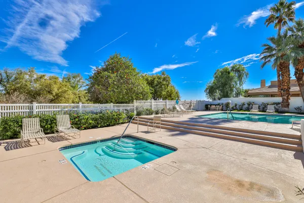 a view of a swimming pool with a patio and a yard