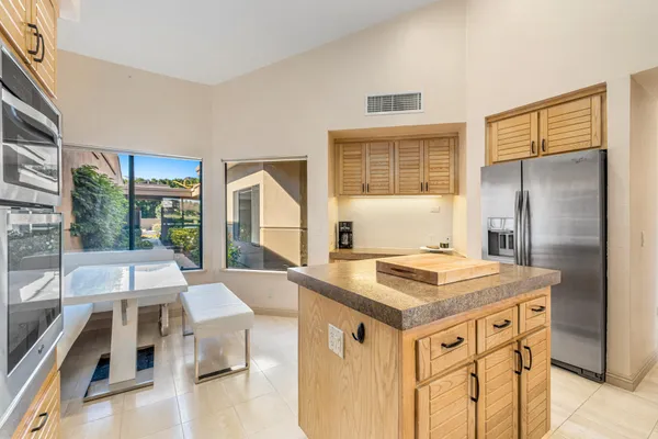a kitchen that has a stove a table and chairs in it