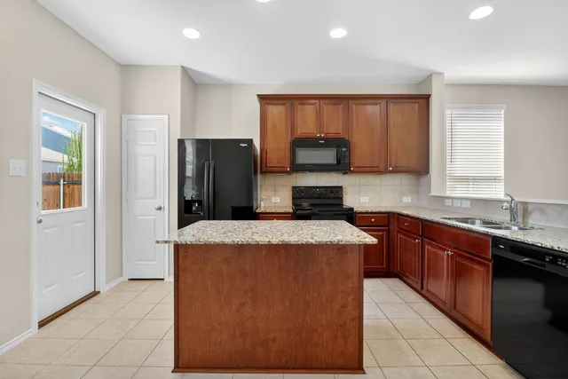 a kitchen with stainless steel appliances granite countertop wooden cabinets a granite counter top and a stove
