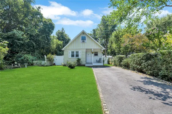 a front view of a house with a yard and trees