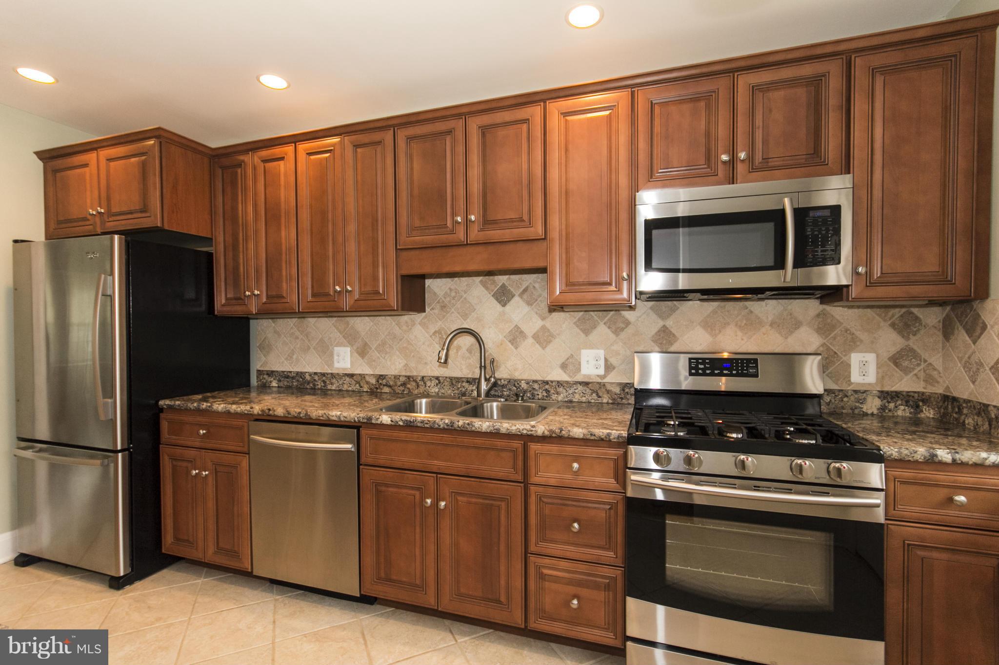 226 Murdock Road Baltimore, MD 21212 - Photo 6 of 19 a kitchen with granite countertop stainless steel appliances a stove a microwave a sink and cabinets