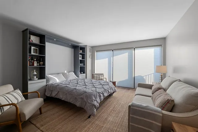 a bedroom with a bed couch and a window