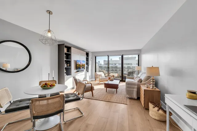 a living room with furniture fireplace and a large window