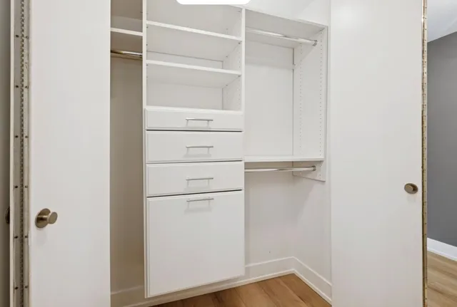a view of walk in closet with empty racks