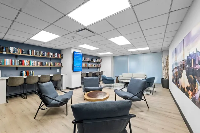 a kitchen with stainless steel appliances granite countertop a sink dishwasher a refrigerator and white cabinets with wooden floor