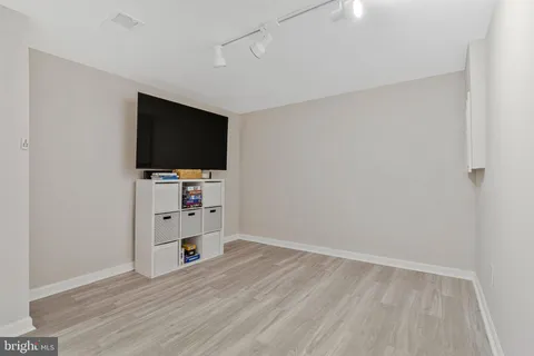 a view of a livingroom with entryway and a flat screen tv