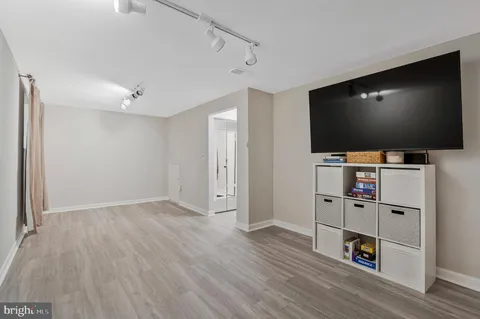 a room with wooden floor and flat screen tv