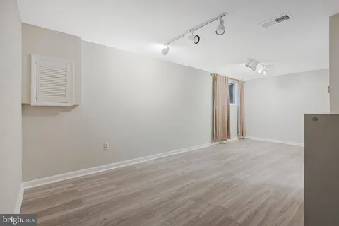 a view of an empty room with wooden floor