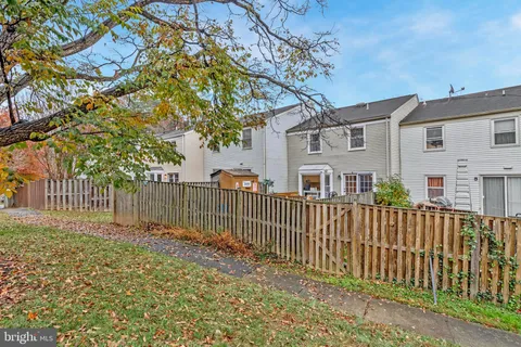 a view of a house with a wooden bench and a bench