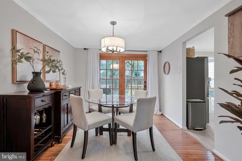 a view of a dining room with furniture a chandelier and wooden floor