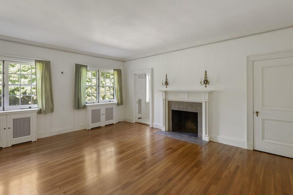 39 Clyde Street Brookline, MA 02467 - Photo 21 of 31 an empty room with wooden floor fireplace and windows