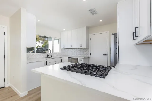 a kitchen with sink a stove and cabinets