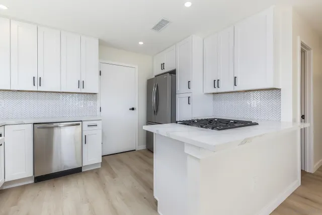 a kitchen with white cabinets and white appliances