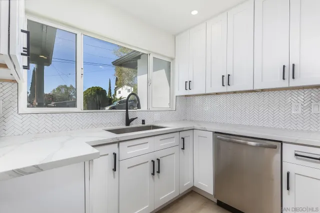 a kitchen with white cabinets and a sink