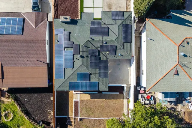 an aerial view of a house with a yard and lake view in back