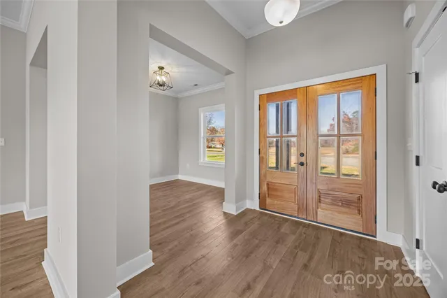 an empty room with wooden floor closet and windows