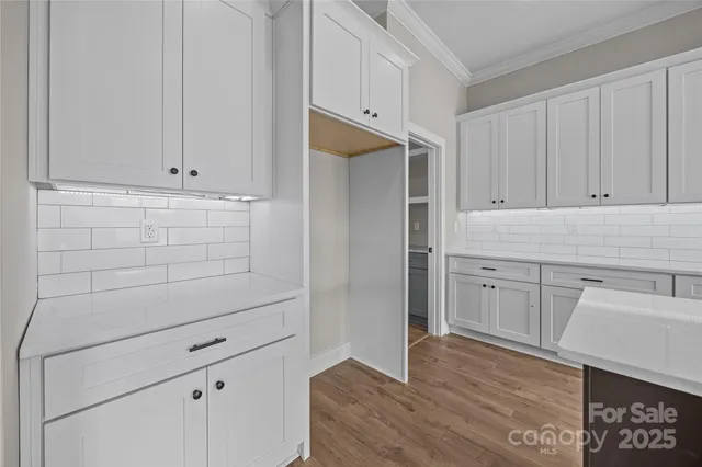 a kitchen with stainless steel appliances granite countertop a sink a stove and a wooden floors