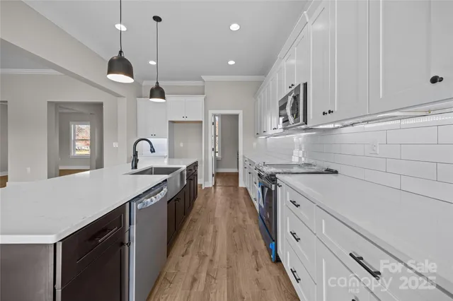 a kitchen with kitchen island white cabinets and sink
