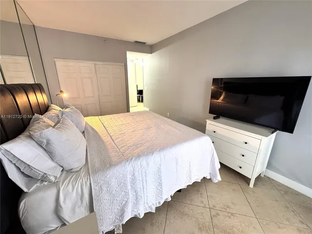 a bedroom with a bed and flat screen tv